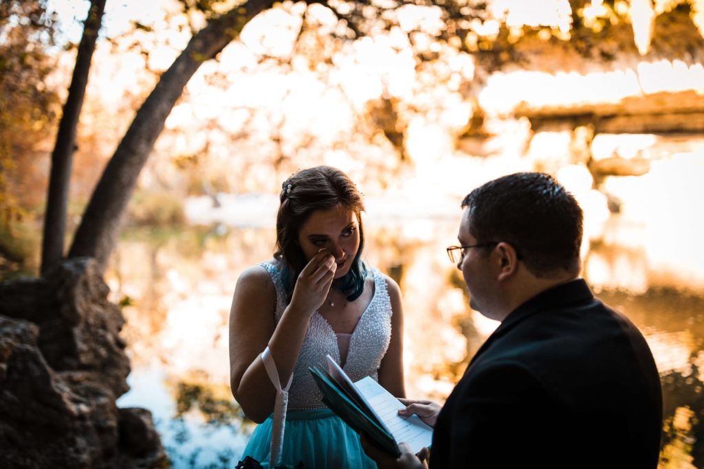 Bride and groom exchanging vows at sunset during their elopement.
