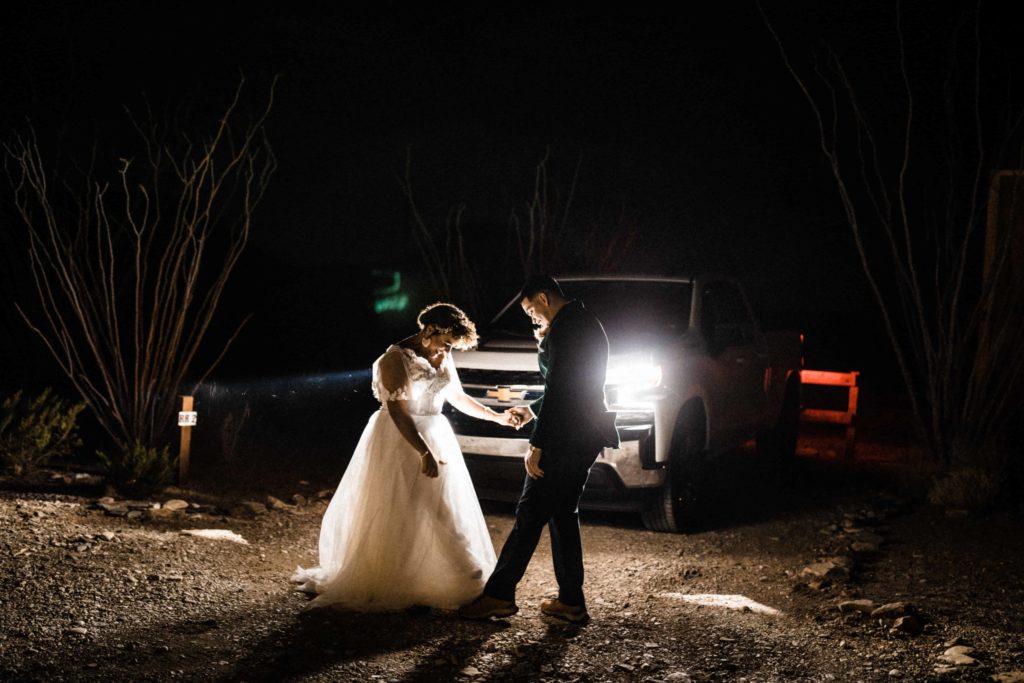 Couple having their first look in the light of their headlights during their big bend elopement