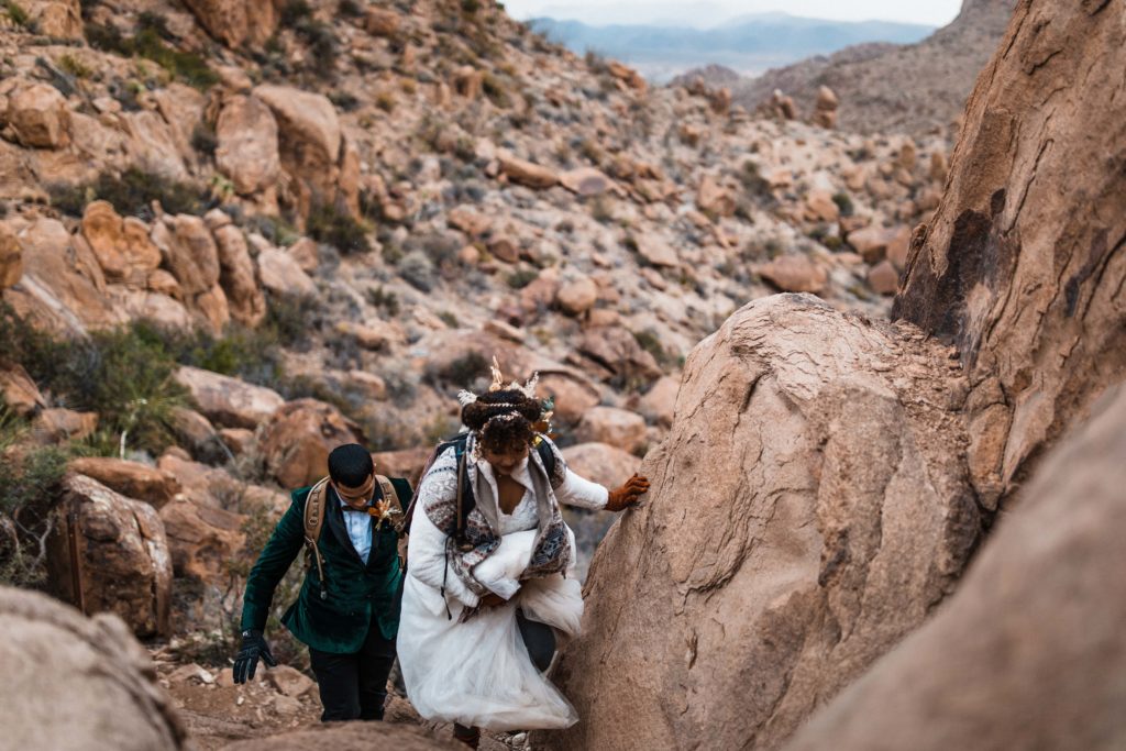 Bride climbing up rocks in her elopement dress.