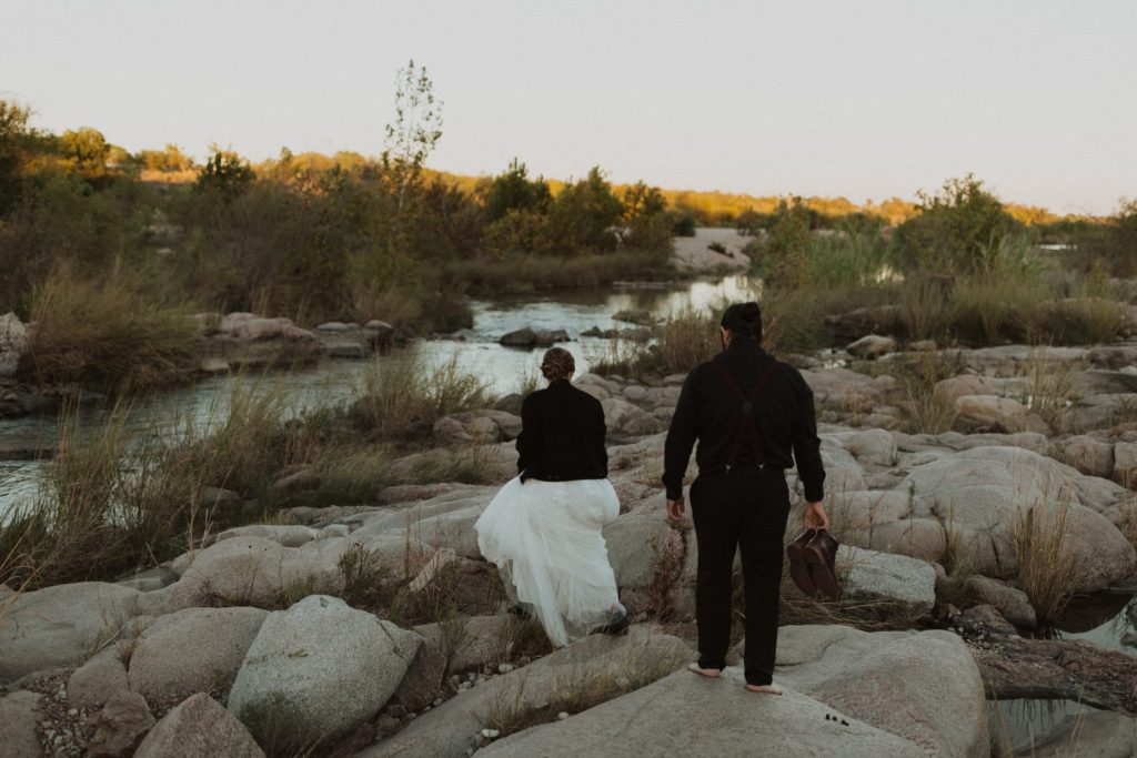 Couple hiking around the Llano River during their Llano River Elopement
