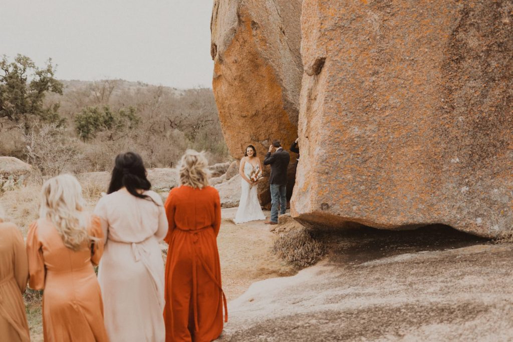 Bride looks back at her guests during her elopement ceremony at Enchanted Rock