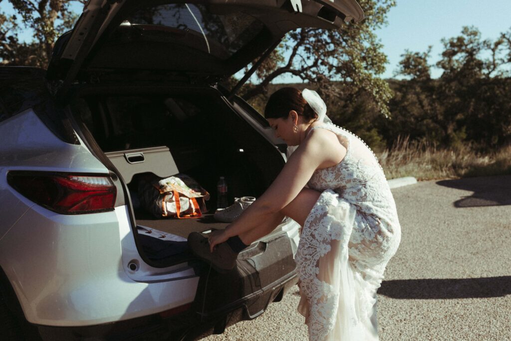Bride putting her hiking boots on for her Pedernales Falls elopement