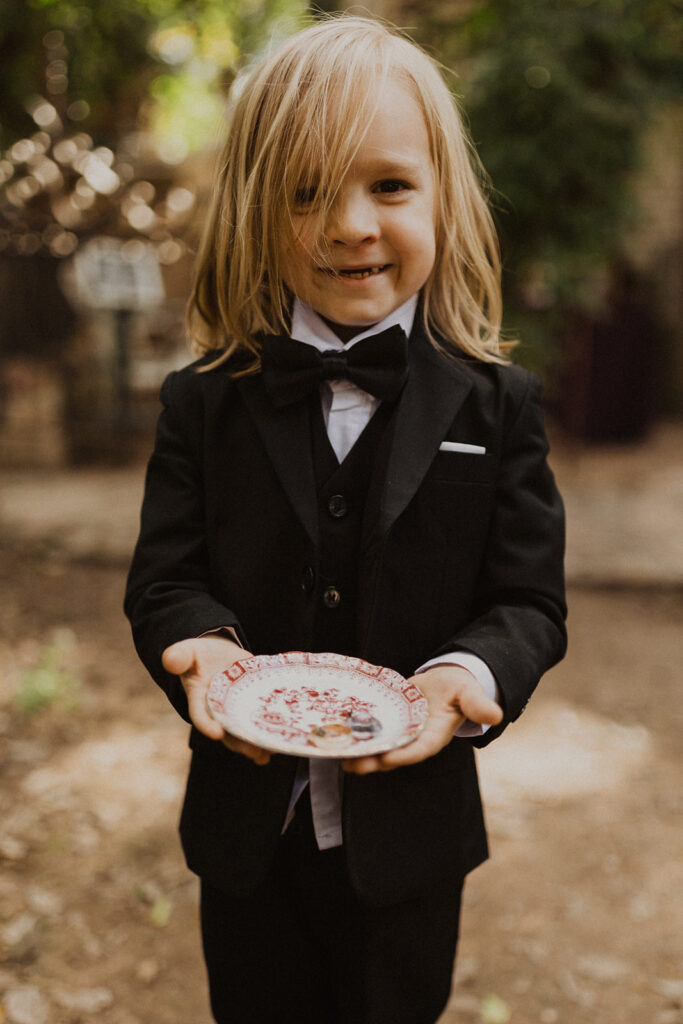 ring bearer holds rings at outdoor wedding 