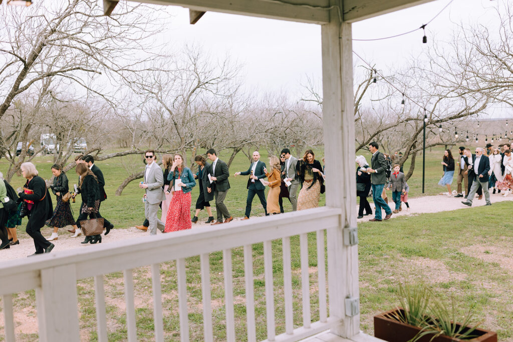 wedding guests walk past couple at Camino Real Ranch wedding 