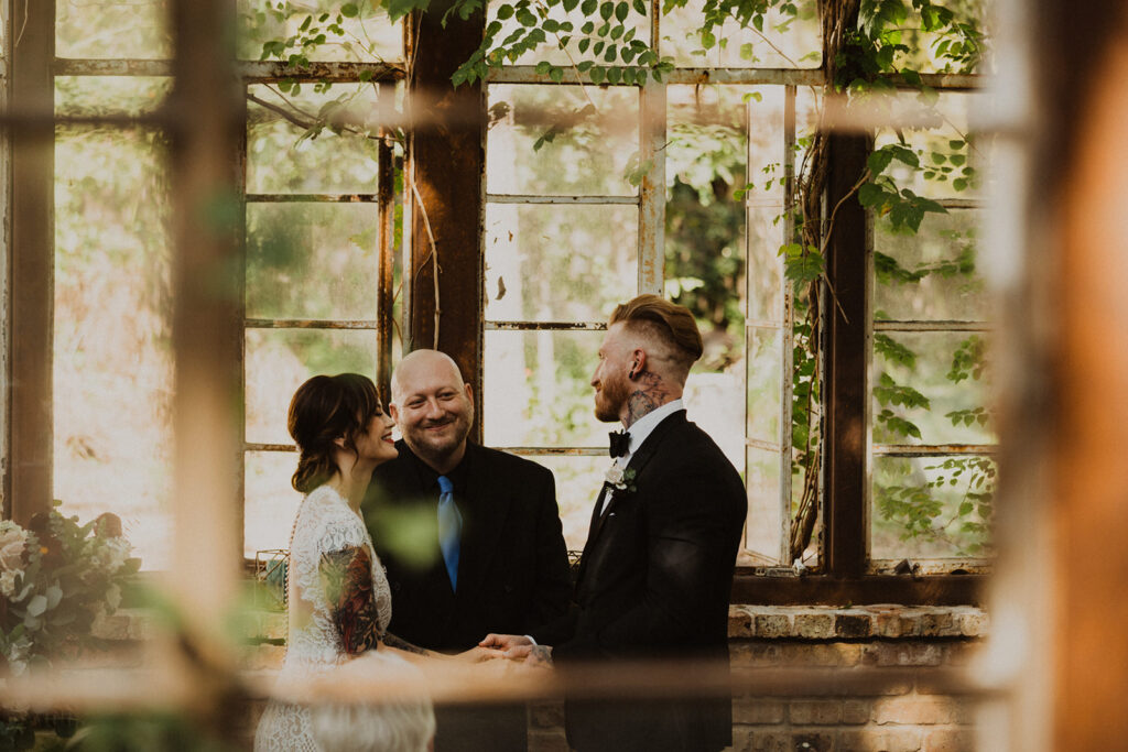 couple exchanges vows at Sekrit Theater vintage greenhouse wedding