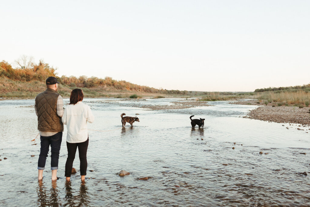 couple plays with dogs at Inks Lake in Texas