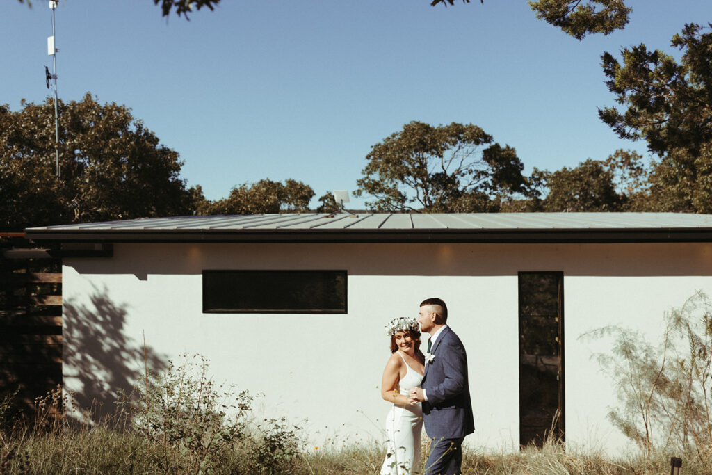 couple embraces in front of wedding venue at Texas elopement
