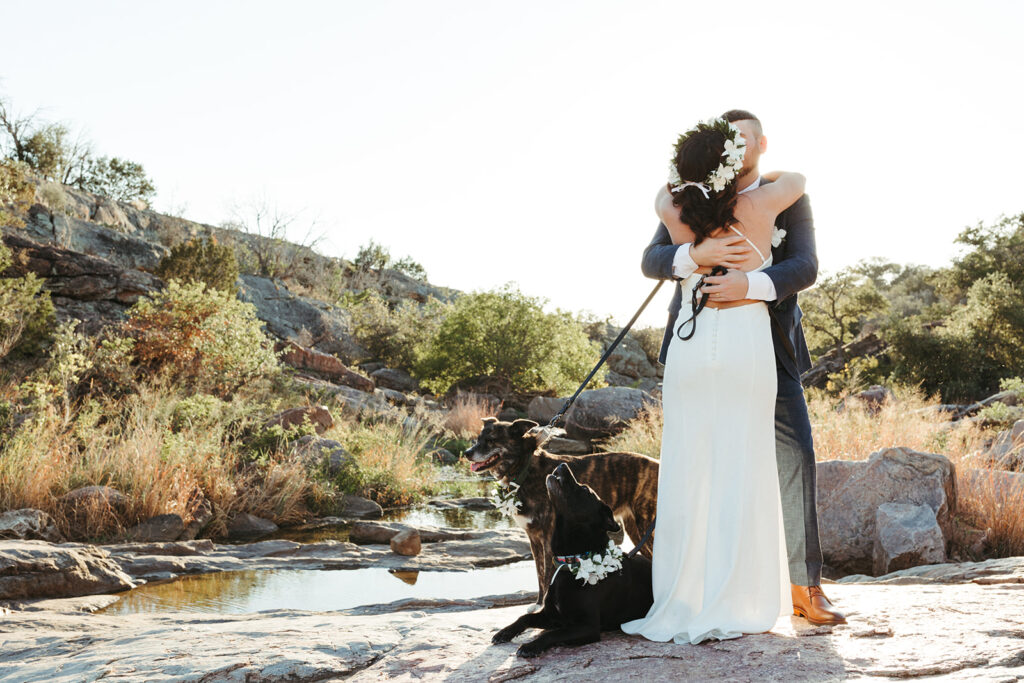 couple kisses with dogs at Inks Lake in Texas elopement