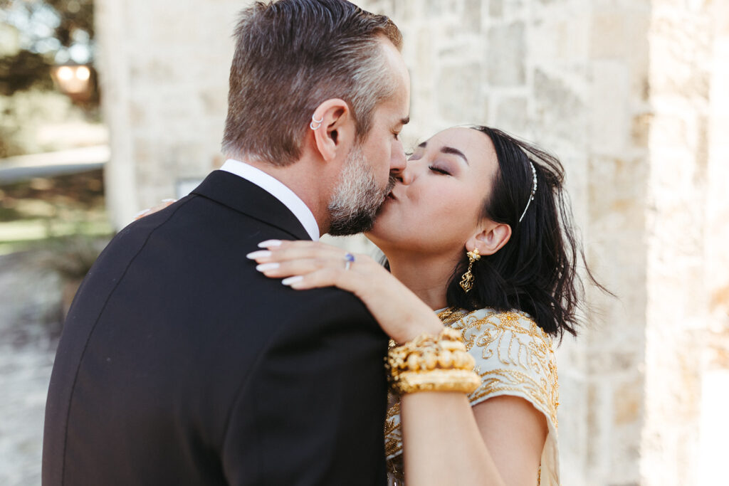 couple kisses during wedding first look