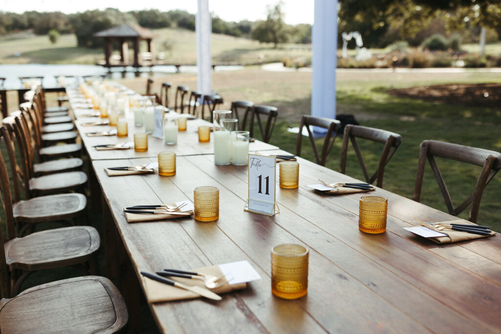 gold and glass wedding decor on wooden table