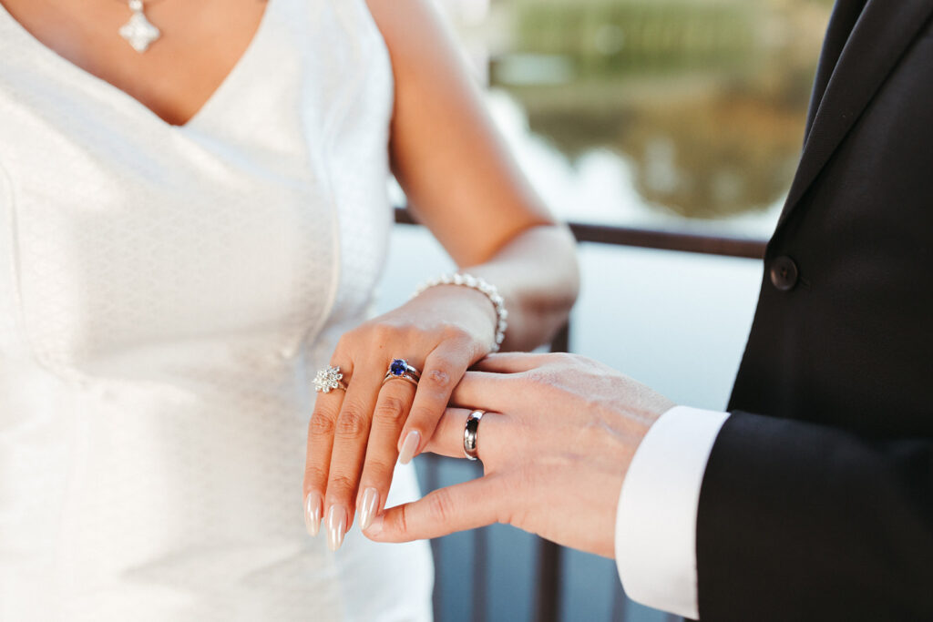 couple holds hands showing wedding bands