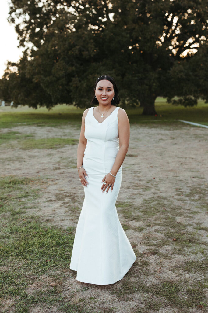 bride poses in white wedding reception dress