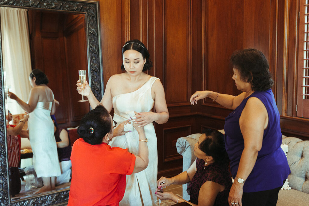 family helps bride get into traditional wedding dress