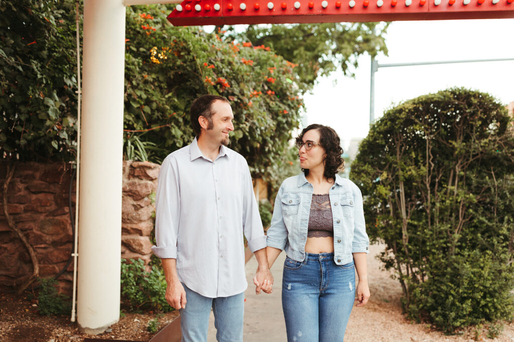 couple walks holding hands at urban engagement session