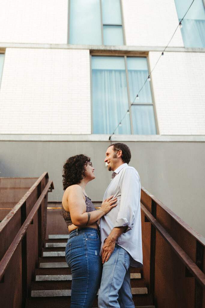 couple embraces on staircase at urban engagement session