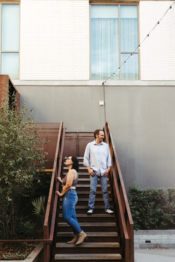 couple stands on staircase at urban engagement session