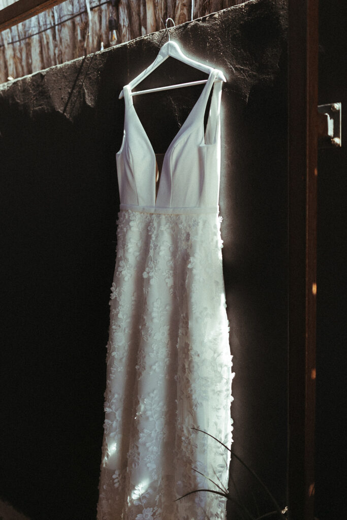 white wedding dress hangs on hanger 