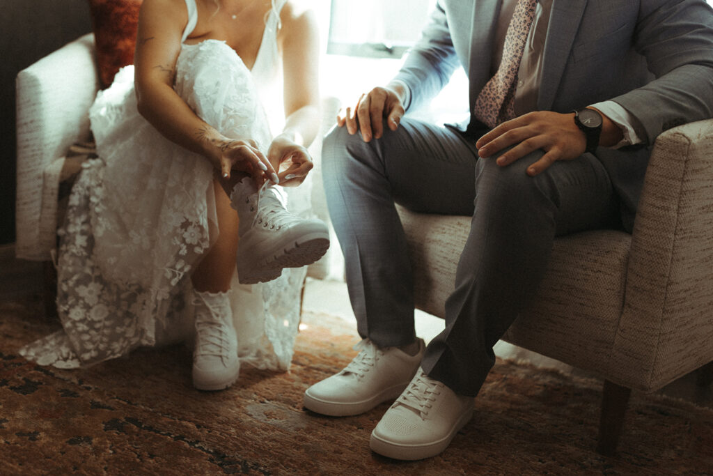 couple ties shoes together on elopement day