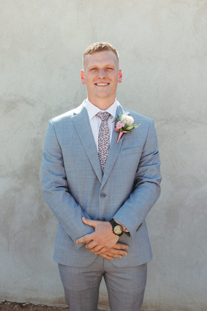 groom poses in suit at Texas Hill Country wedding elopement