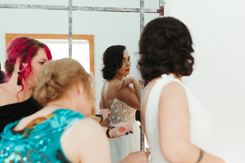 bride has dress tied during wedding getting ready