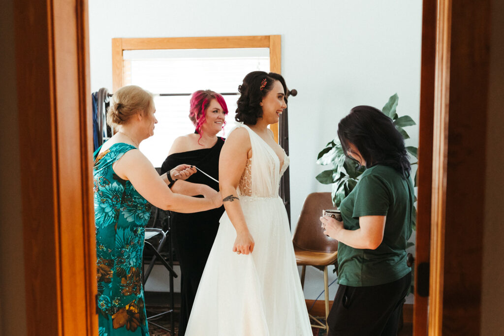 bride has dress tied during wedding getting ready