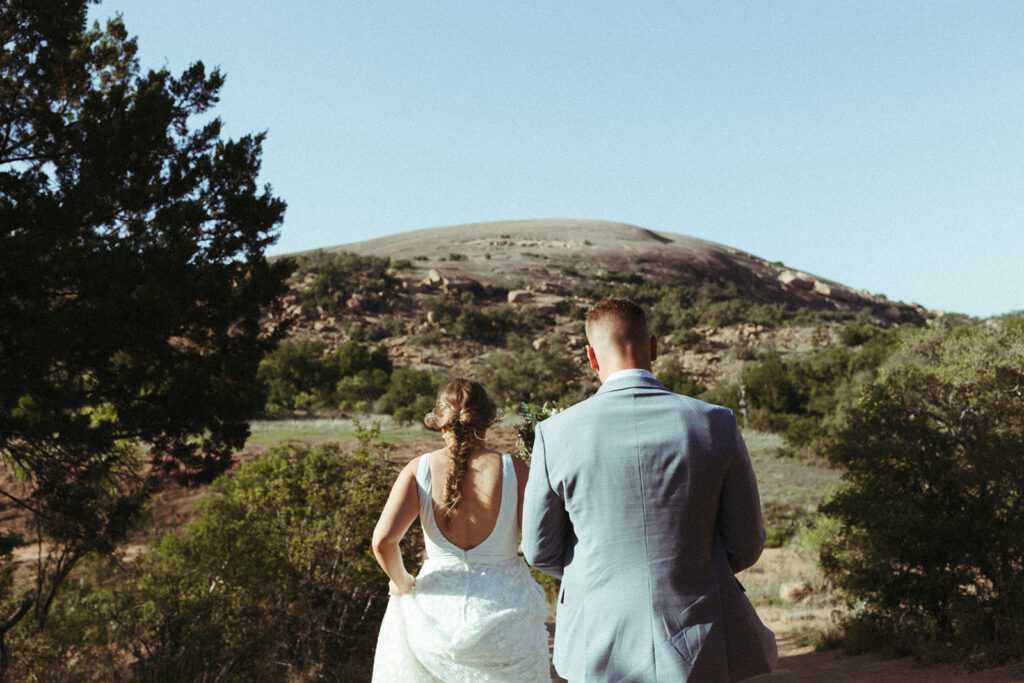couple walks towards enchanted rock mountain 