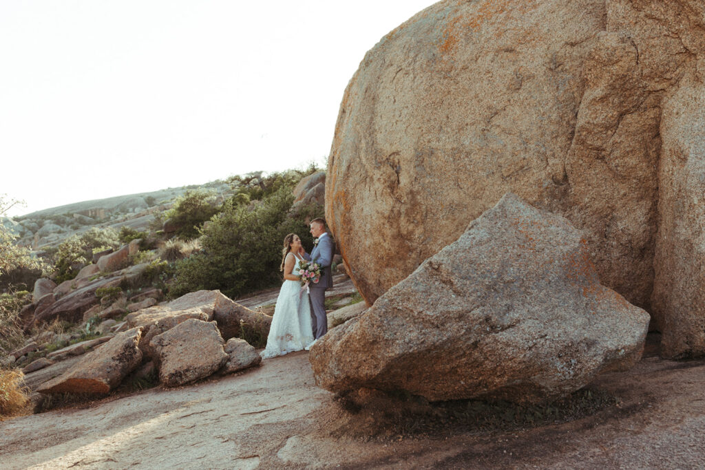 couple stands beside rock at Texas Hill Country wedding elopement