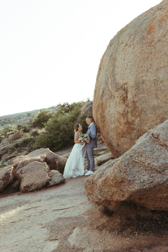 couple leans against rock at enchanted rock sunset elopement