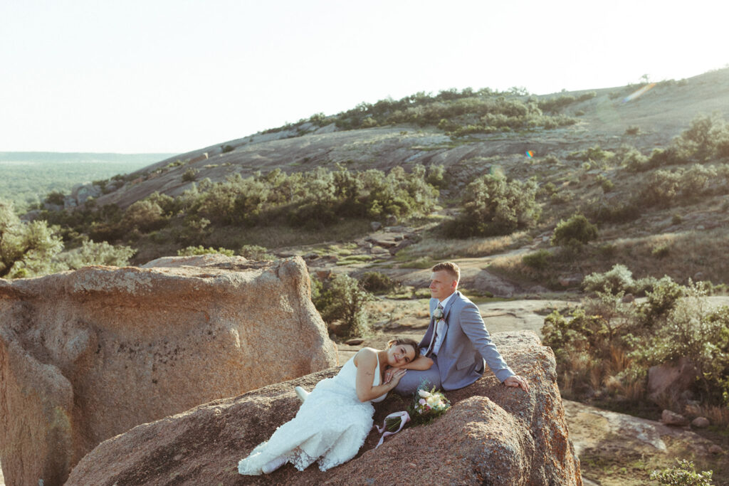 couple sits on rock at enchanted rock park 
