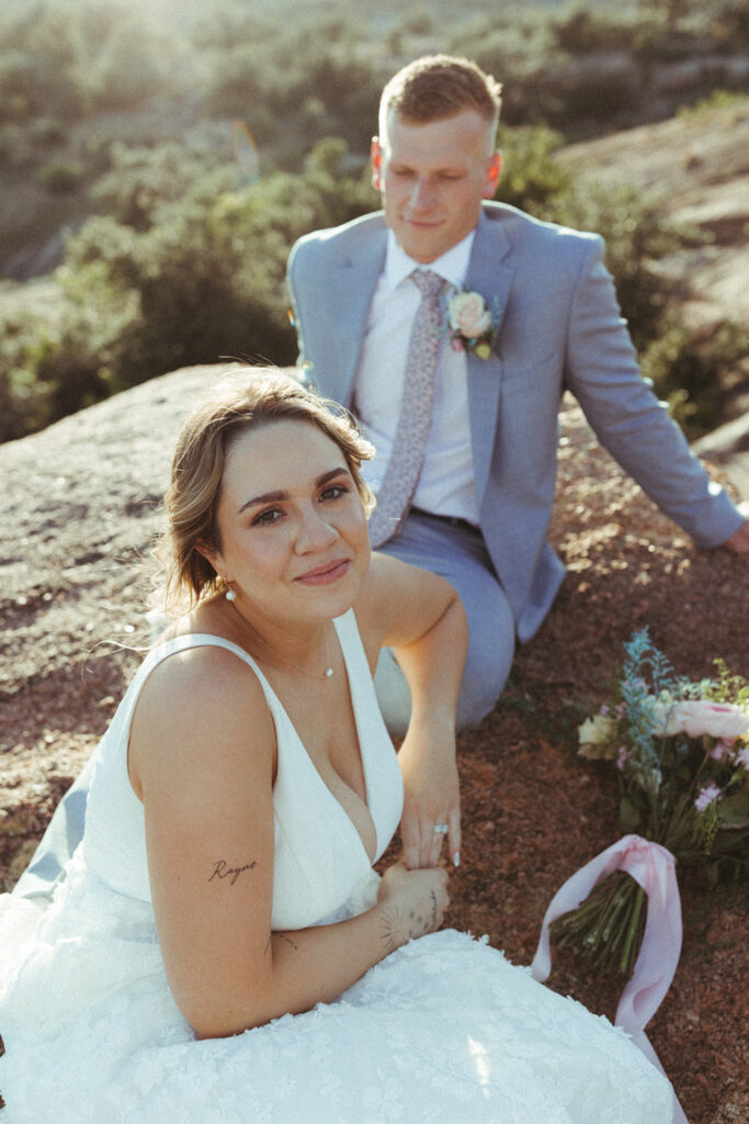 couple sits on rock together at Texas Hill Country wedding elopement