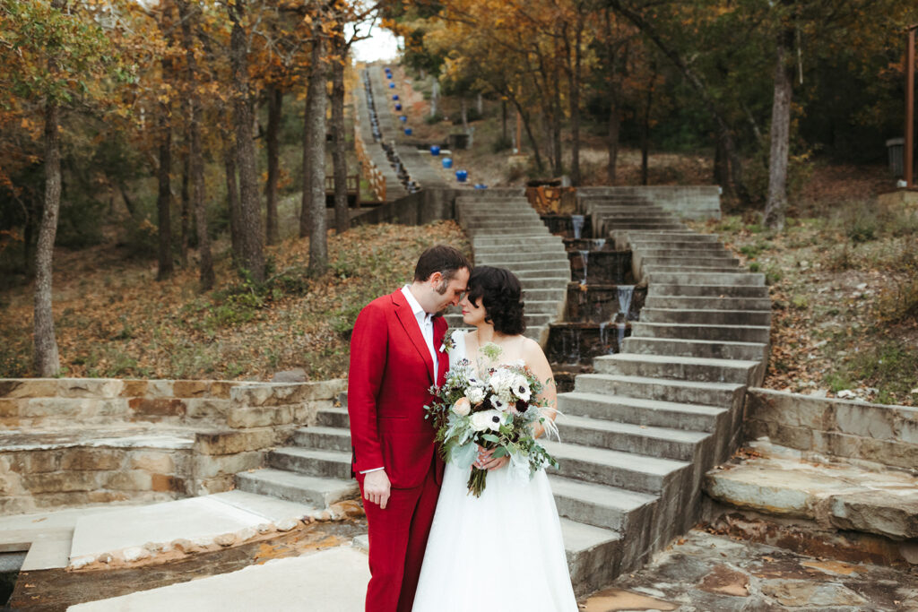 couple embraces at bottom of staircase at Shiraz Garden in Texas