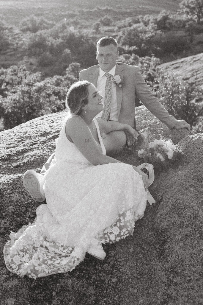 couple sits on rock at Texas Hill Country wedding elopement