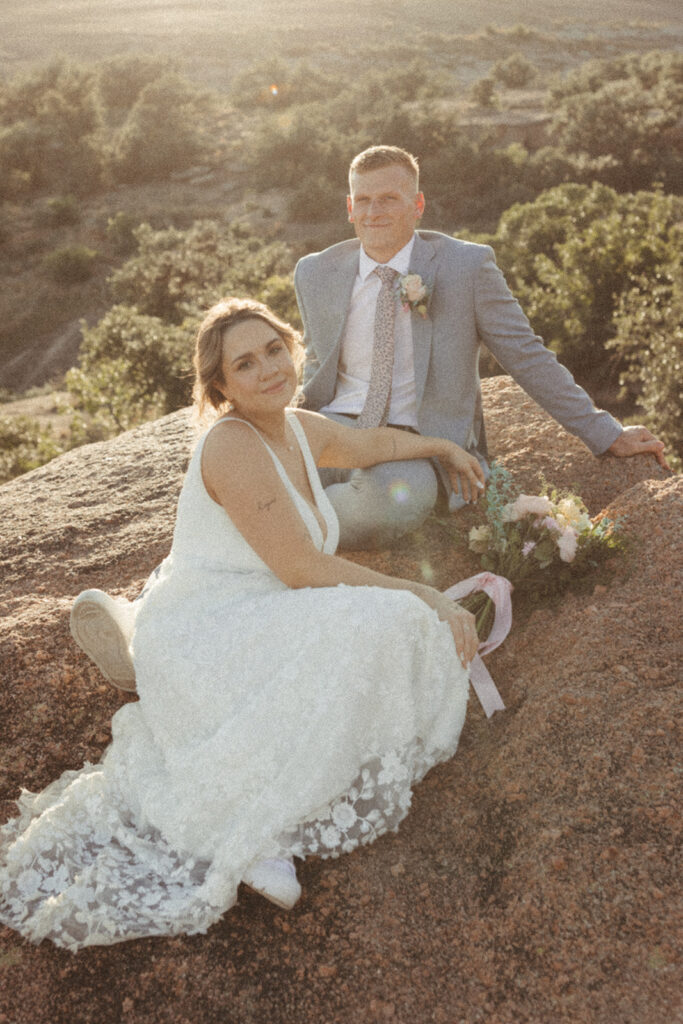 couple sits together at enchanted rock sunset elopement