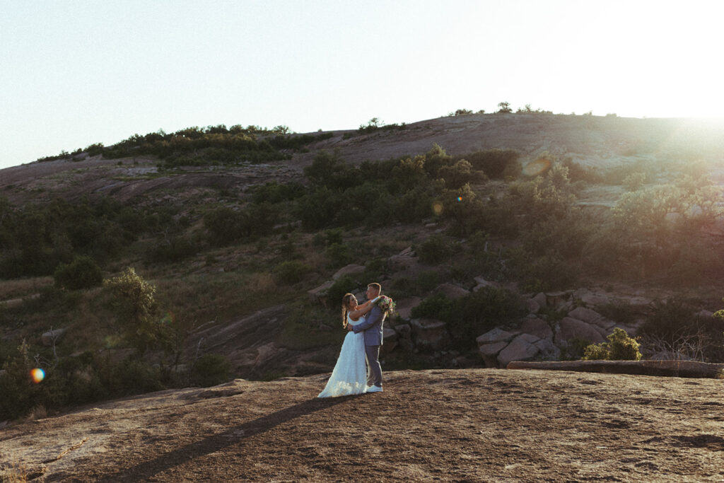 couple embraces on mountain at Texas Hill Country wedding elopement