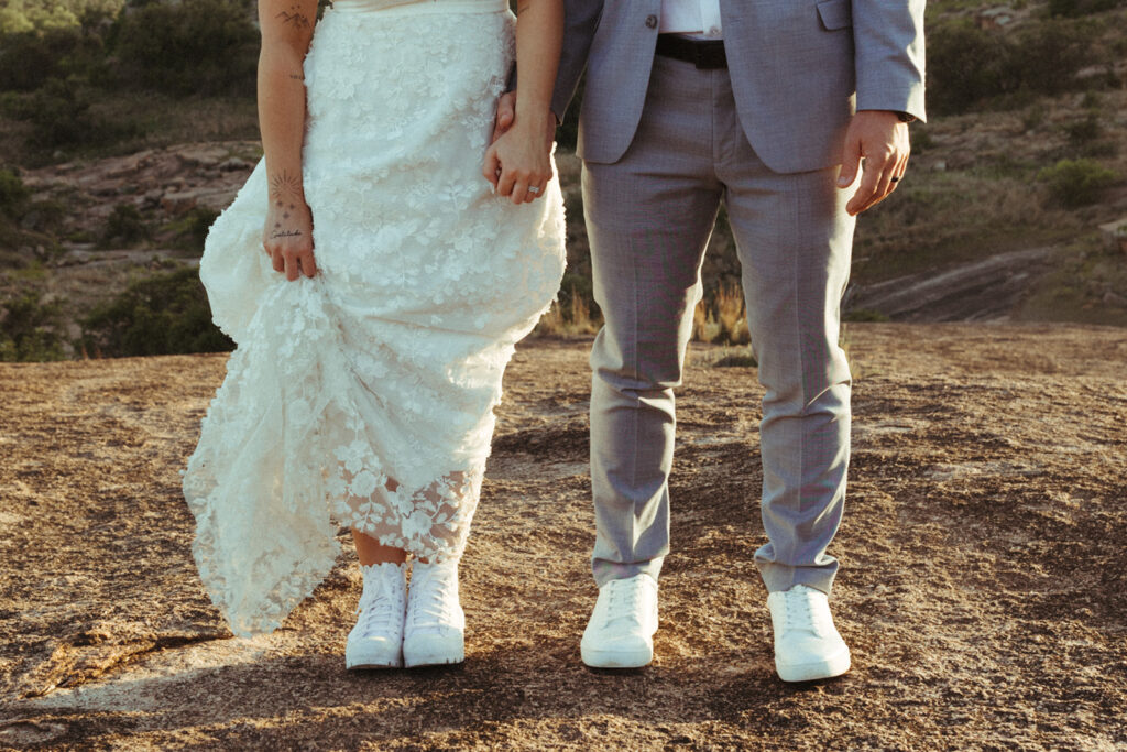 couple holds hands with matching white shoes at Texas Hill Country wedding elopement