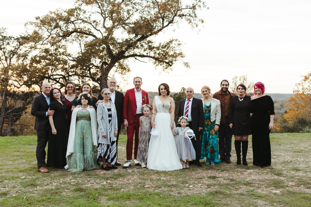 couple poses with family under tree at Shiraz Garden in Texas