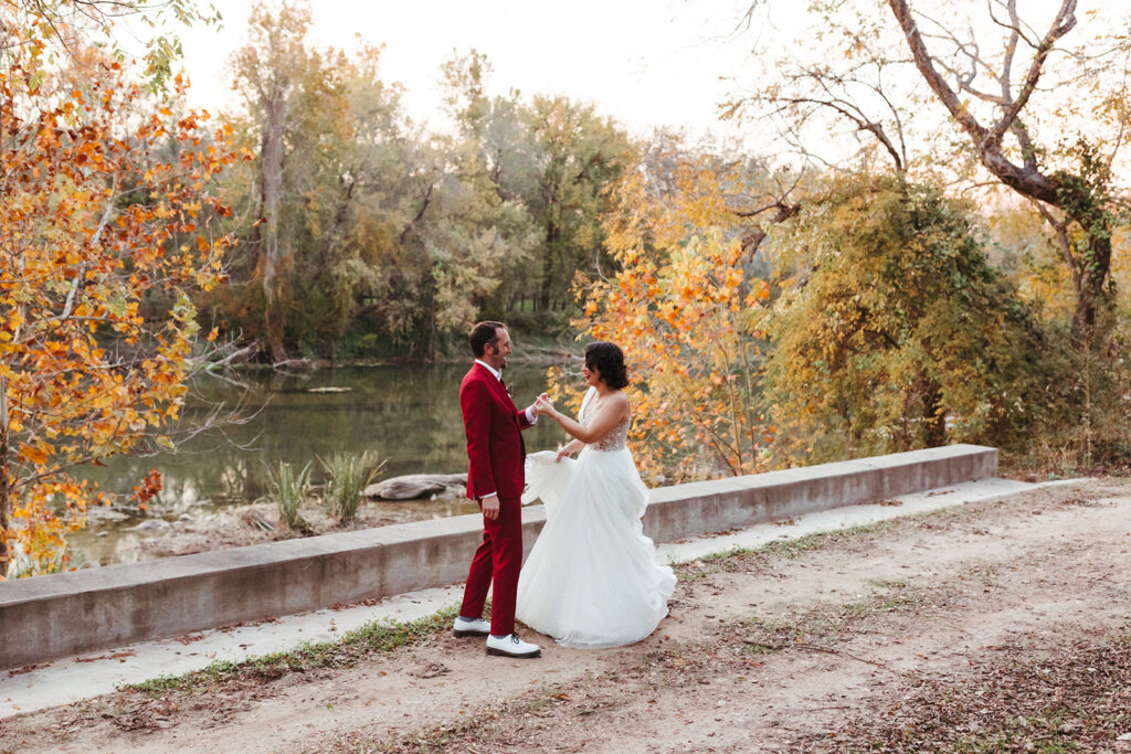 couple stands by river at Shiraz Garden in Texas