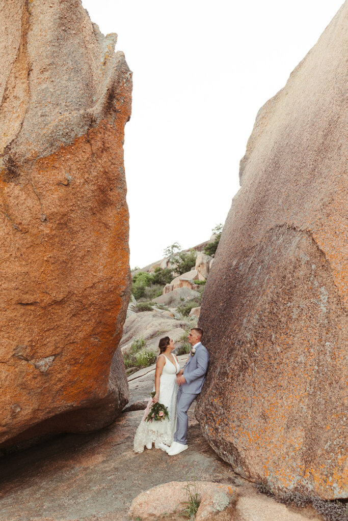 couple leans against rock at enchanted rock sunset elopement