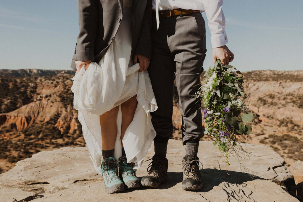 couple wears hiking shoes during outdoor sunrise elopement