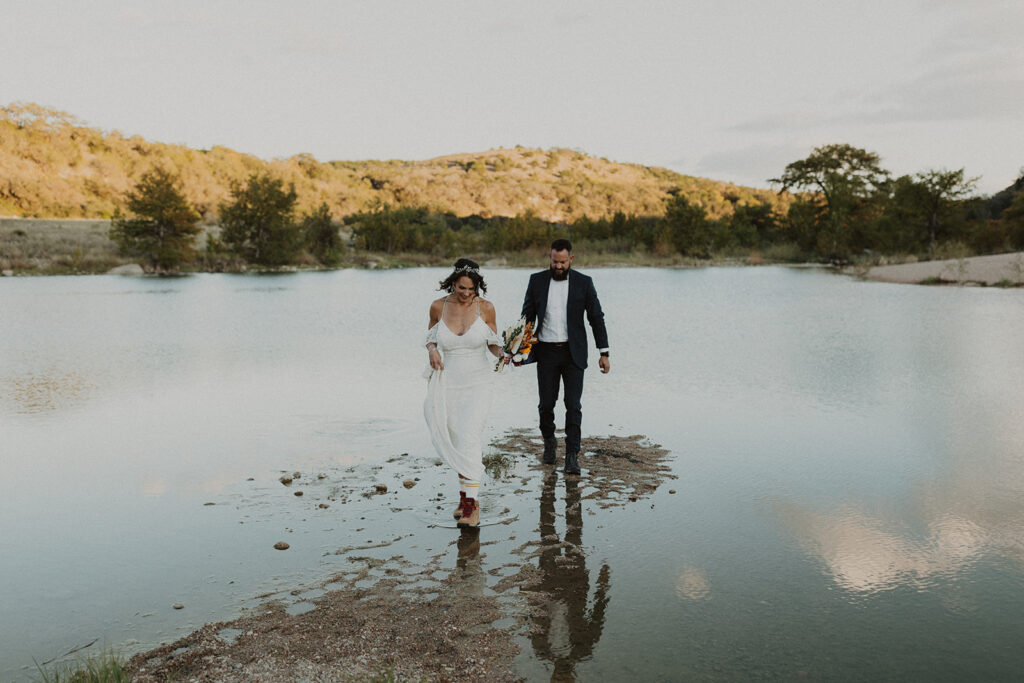 couple walks across lake during texas elopement