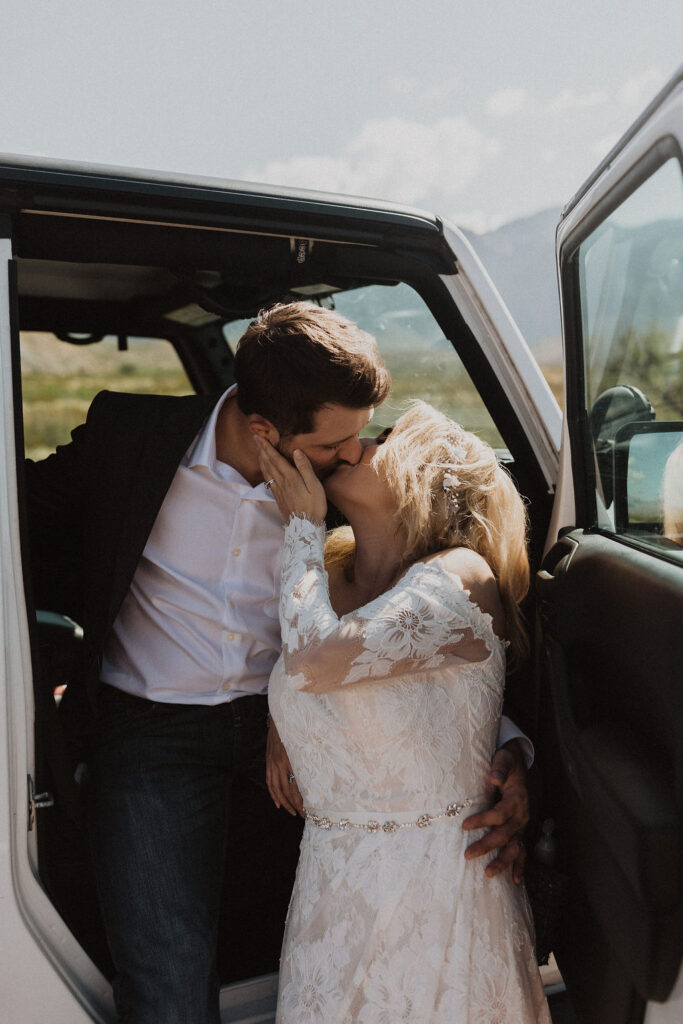couple kisses beside Jeep during adventure elopement