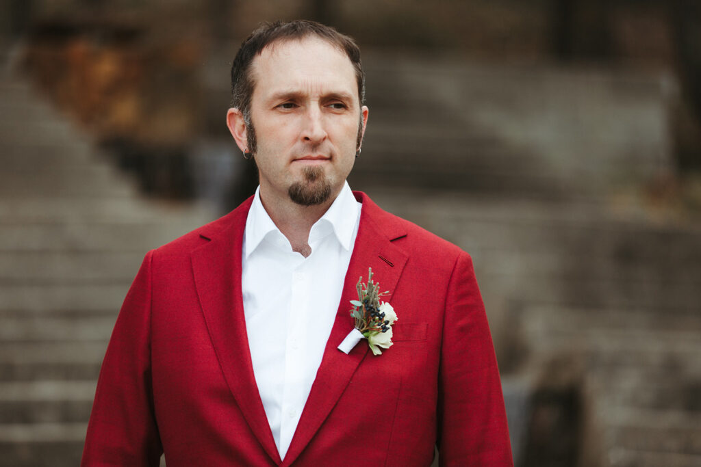 groom wears red wedding suit