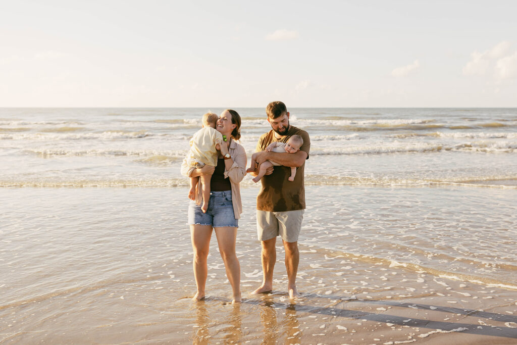 Young family taking family photos at Galveston Beach in Texas